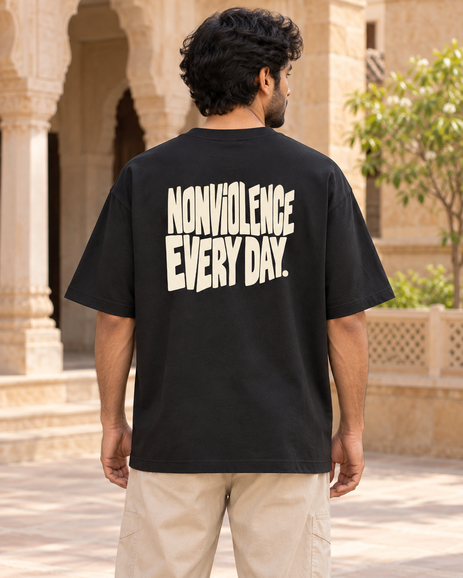 Nonviolence, every day — back view · Black oversized T-shirt · Styling illustration.